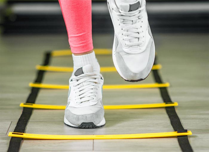 عکس ورزشکار ایروبیک در حال تمرین با نردبان چابکی