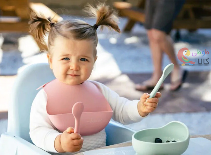 کودک در حال غذا خوردن با قاشق چنگال سیلیکونی
