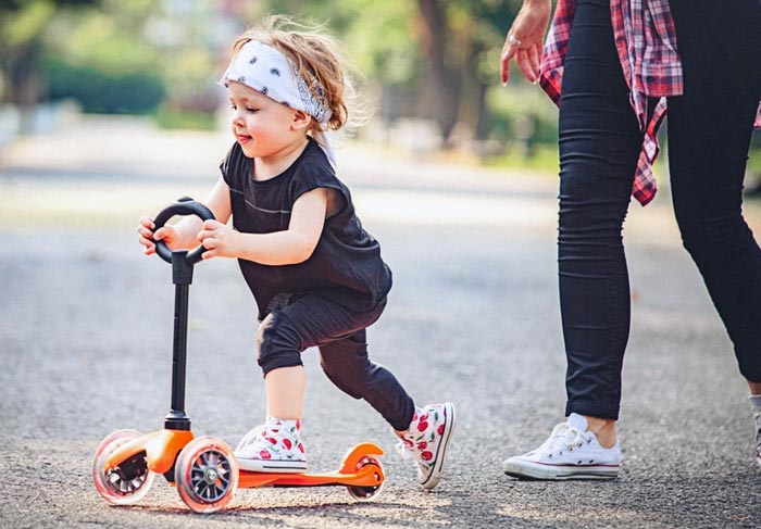 کودک در حال بازی با اسکوتر 3 چرخ